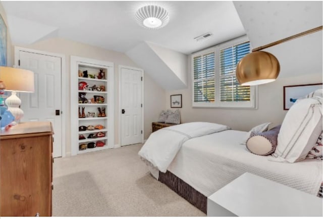 bedroom with vaulted ceiling and light colored carpet