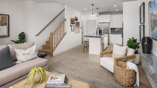 living room with sink and light wood-type flooring