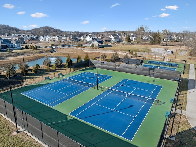 view of tennis court with a water view