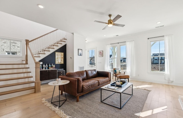 living room featuring ceiling fan and light hardwood / wood-style floors