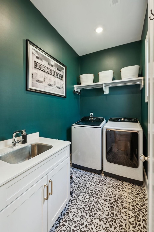 laundry area featuring sink, washing machine and dryer, cabinets, and light tile patterned flooring