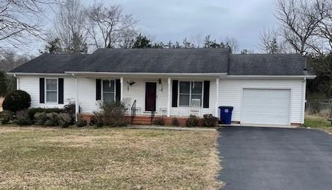 ranch-style home with a garage and a front lawn