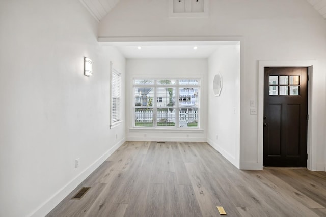 entrance foyer with vaulted ceiling and light hardwood / wood-style floors