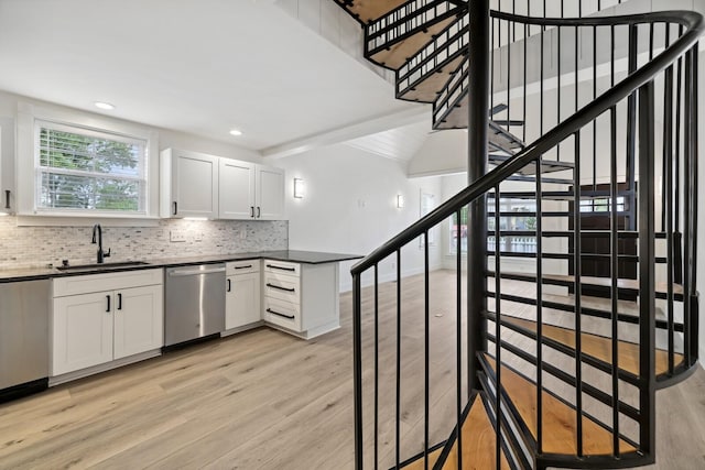 kitchen with light wood-type flooring, dishwasher, sink, and white cabinets