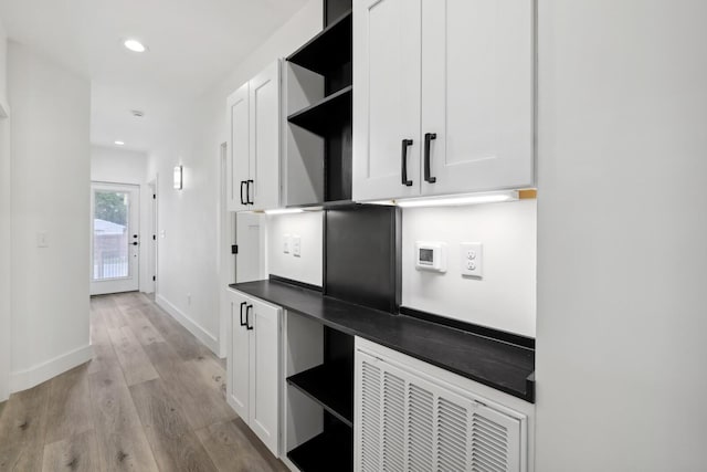 kitchen with white cabinetry and light hardwood / wood-style flooring