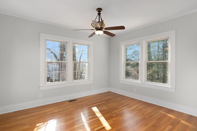 spare room with hardwood / wood-style flooring, crown molding, and ceiling fan