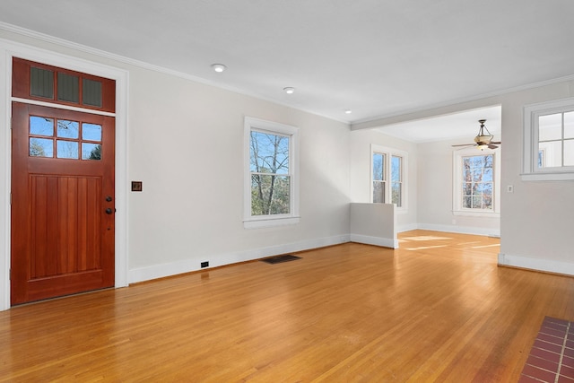 foyer with crown molding and light hardwood / wood-style floors