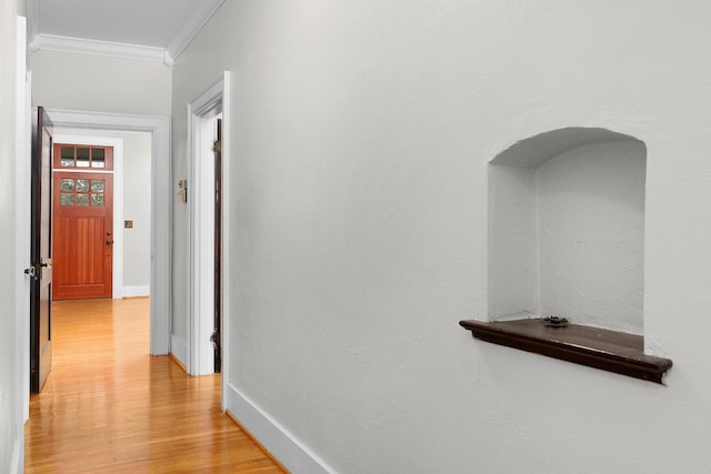 hall featuring ornamental molding and light hardwood / wood-style floors