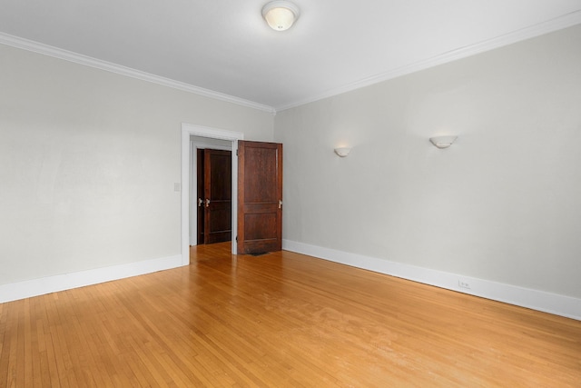 empty room featuring hardwood / wood-style flooring and crown molding