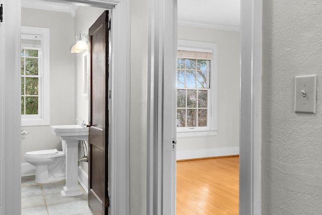 bathroom featuring crown molding, toilet, and hardwood / wood-style flooring