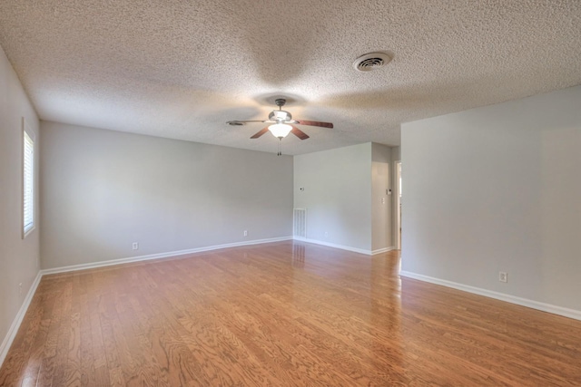 unfurnished room with ceiling fan, wood-type flooring, and a textured ceiling