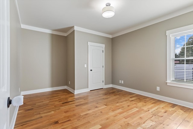 spare room with crown molding and light hardwood / wood-style flooring