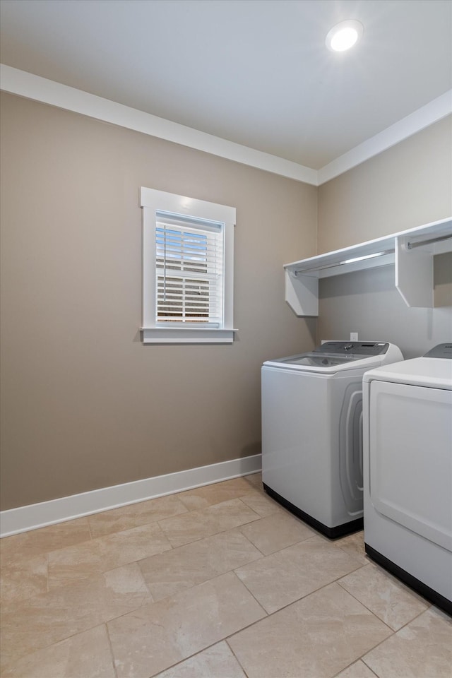 clothes washing area featuring light tile patterned flooring, crown molding, and separate washer and dryer