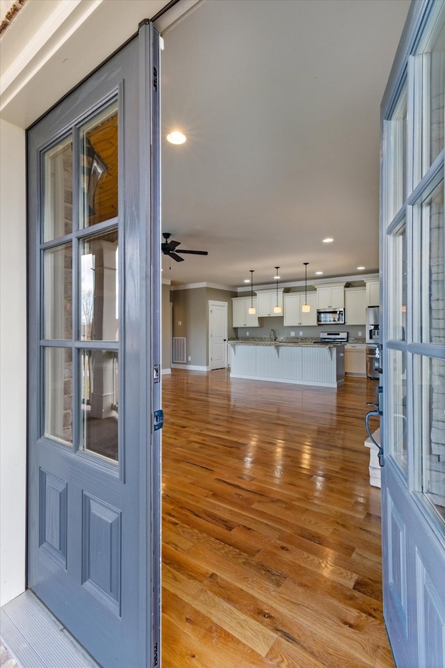 unfurnished living room featuring ceiling fan and light hardwood / wood-style flooring