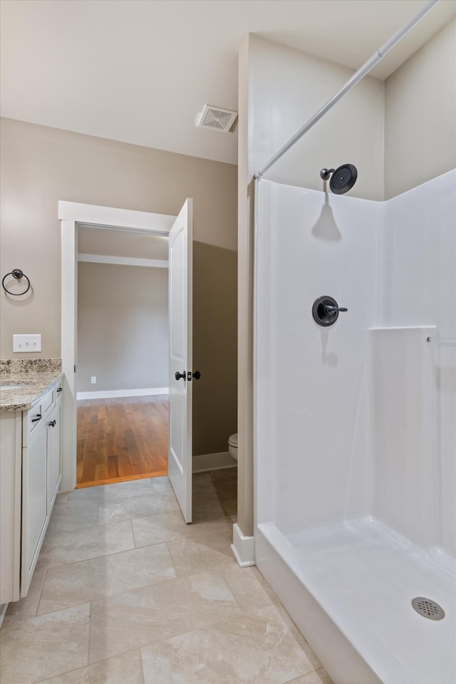 bathroom with vanity, a shower, and toilet