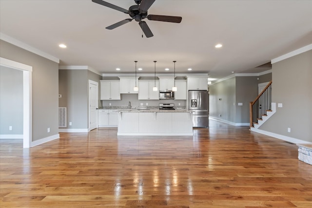 unfurnished living room with crown molding, ceiling fan, sink, and light hardwood / wood-style floors