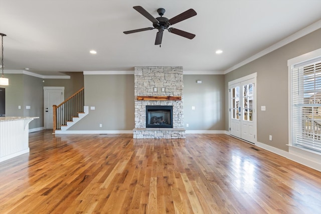 unfurnished living room with crown molding, a fireplace, and light hardwood / wood-style flooring