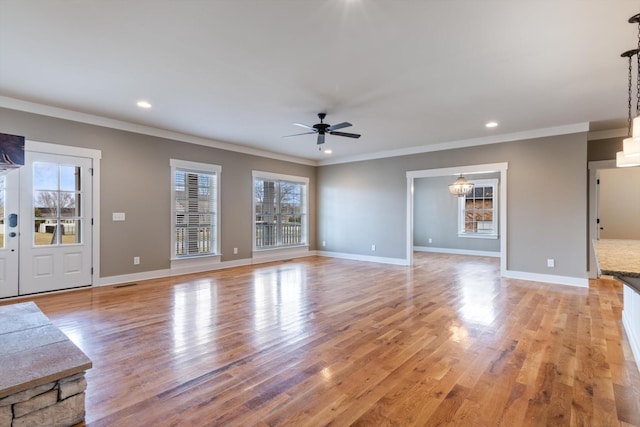 unfurnished living room with ornamental molding, light hardwood / wood-style floors, and a wealth of natural light