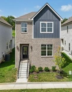 view of front of property with central AC and a front lawn