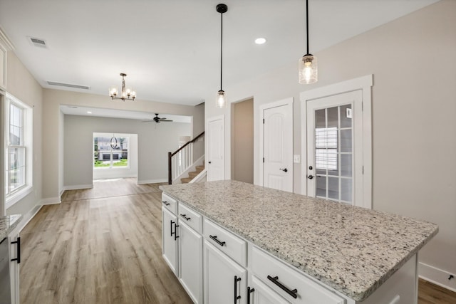 kitchen with white cabinetry, a center island, and pendant lighting