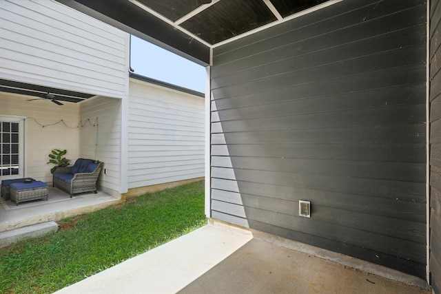 entrance to property with a patio, outdoor lounge area, and ceiling fan