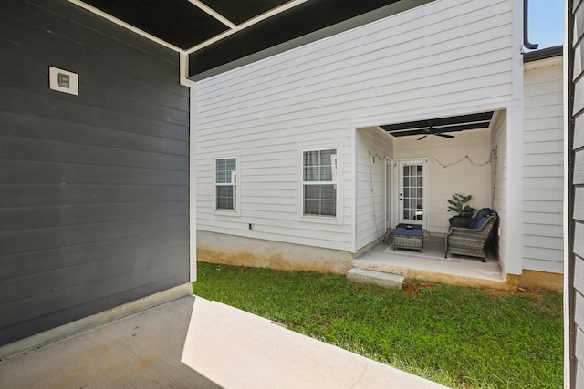 property entrance featuring a yard, ceiling fan, and a patio area