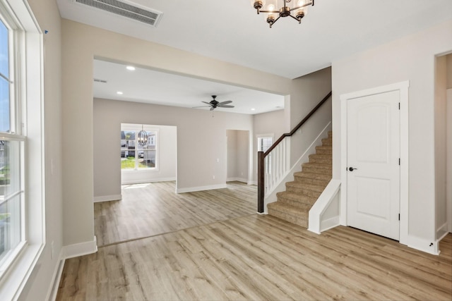 foyer featuring ceiling fan with notable chandelier and light wood-type flooring