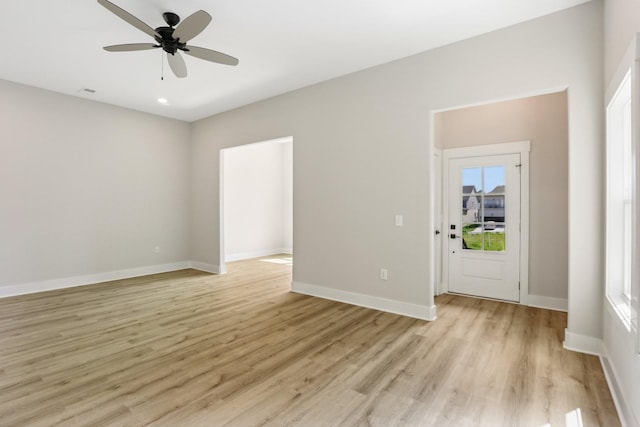 empty room with ceiling fan and light hardwood / wood-style floors