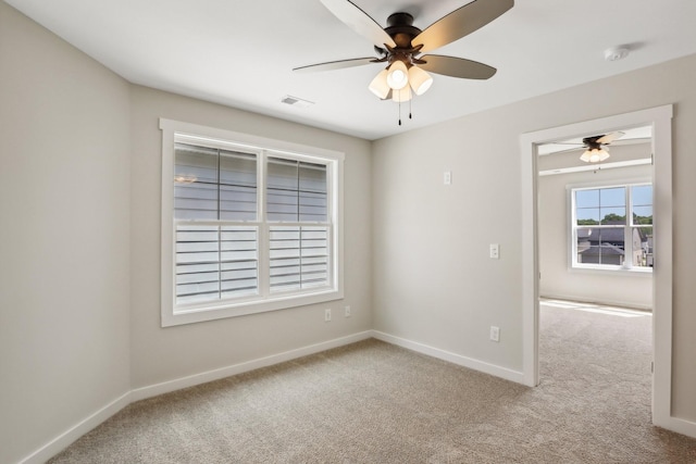 carpeted spare room featuring ceiling fan