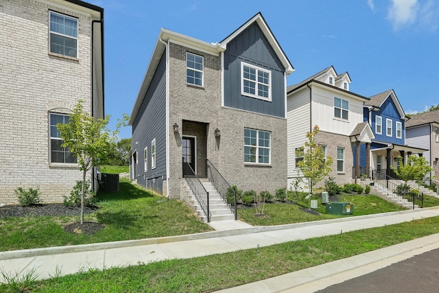 view of front of home featuring a front yard and central air condition unit