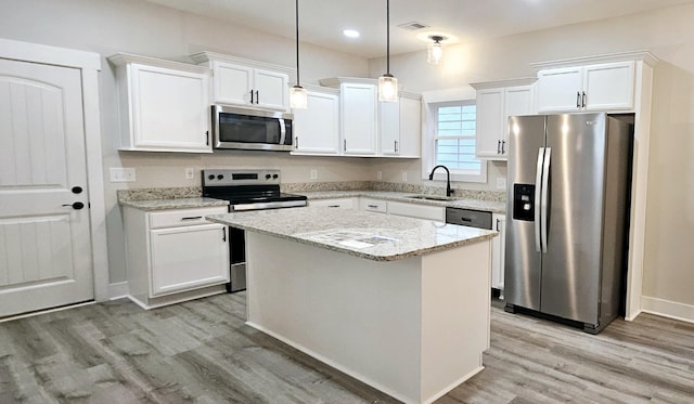 kitchen featuring white cabinetry, sink, stainless steel appliances, and a kitchen island