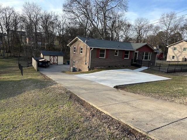 view of front of home with a storage shed and a front yard