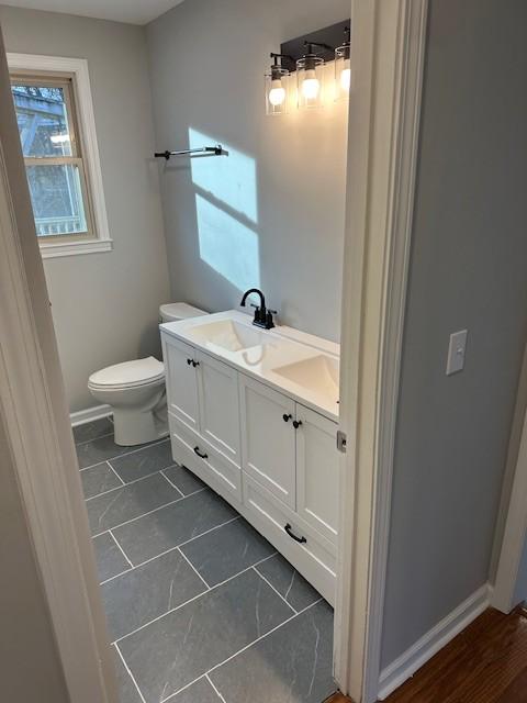 bathroom with tile patterned flooring, vanity, and toilet