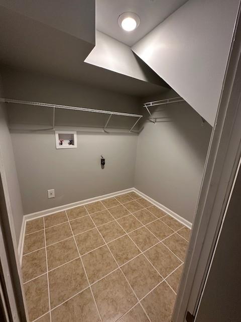 clothes washing area featuring laundry area, hookup for a washing machine, and tile patterned floors