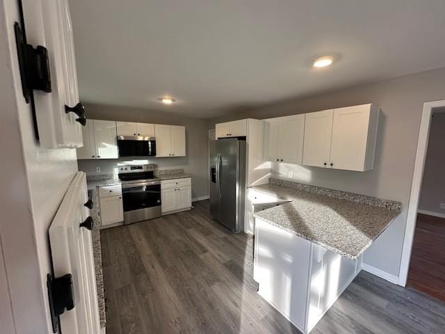 kitchen with light stone counters, dark wood-style flooring, baseboards, white cabinets, and appliances with stainless steel finishes