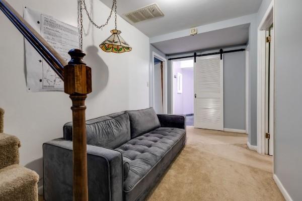 living room featuring a barn door and carpet floors