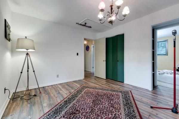 interior space featuring wood-type flooring, an inviting chandelier, and a closet