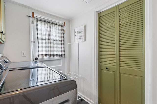 laundry area with independent washer and dryer, cabinets, and ornamental molding