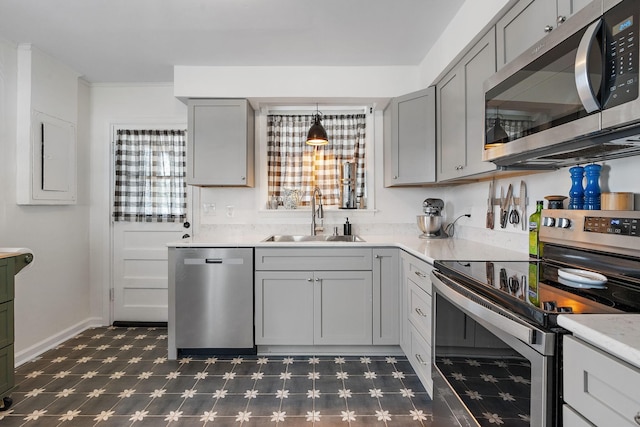 kitchen featuring stainless steel appliances, sink, hanging light fixtures, and gray cabinetry