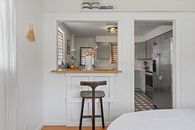 interior space featuring butcher block countertops, gray cabinets, and appliances with stainless steel finishes