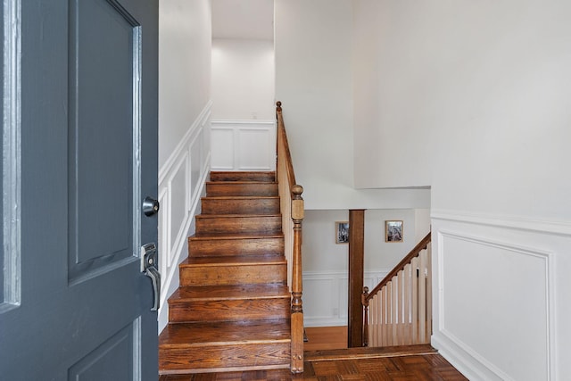 stairs featuring parquet flooring