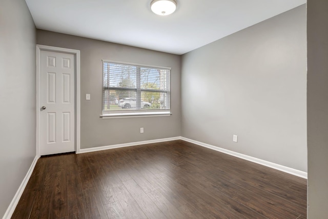 unfurnished room with dark wood-type flooring