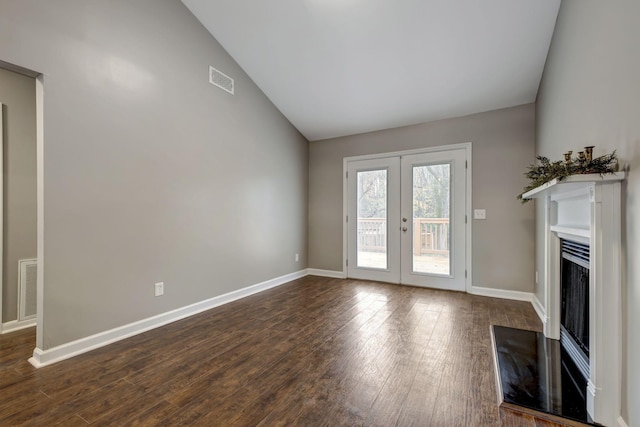 unfurnished living room with visible vents, vaulted ceiling, dark wood-type flooring, and french doors