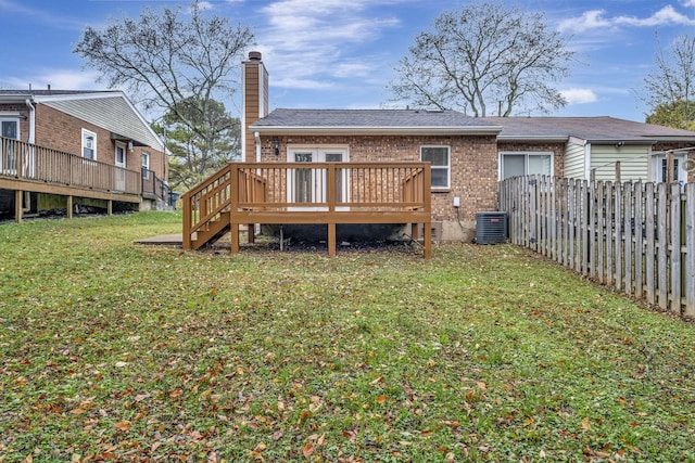 rear view of house with a wooden deck, a yard, and central AC unit