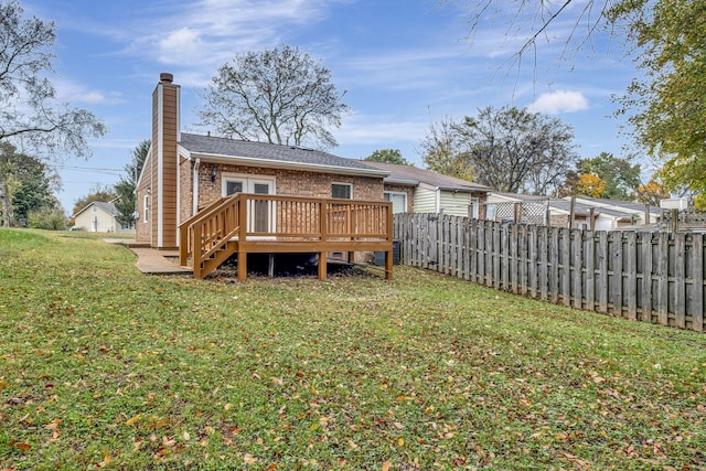 back of property featuring a lawn and a deck