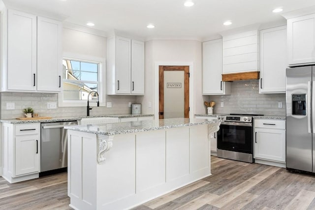 kitchen featuring white cabinetry, a center island, and appliances with stainless steel finishes