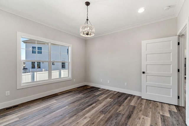 unfurnished room featuring wood-type flooring, ornamental molding, and a notable chandelier