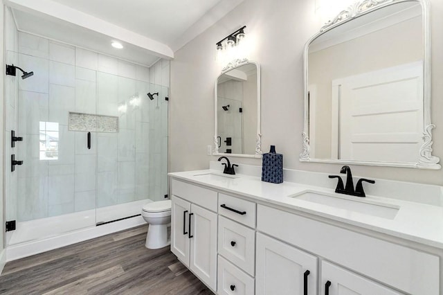 bathroom with an enclosed shower, vanity, hardwood / wood-style flooring, and toilet