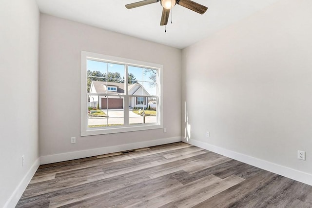 empty room with ceiling fan and light wood-type flooring