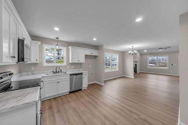 kitchen featuring appliances with stainless steel finishes, light hardwood / wood-style floors, sink, and white cabinets